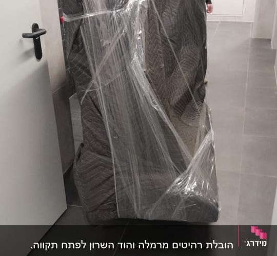 רהיט עטוף בניילון מוכן להובלה במסדרון